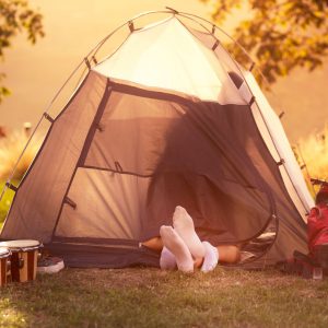 2 pair of sock feet sticking out of a tent